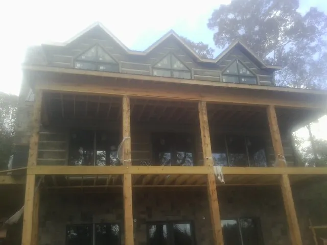 Dormers and porch framing on a large log home under construction — Roof Coating work by our crew in Shellsburg